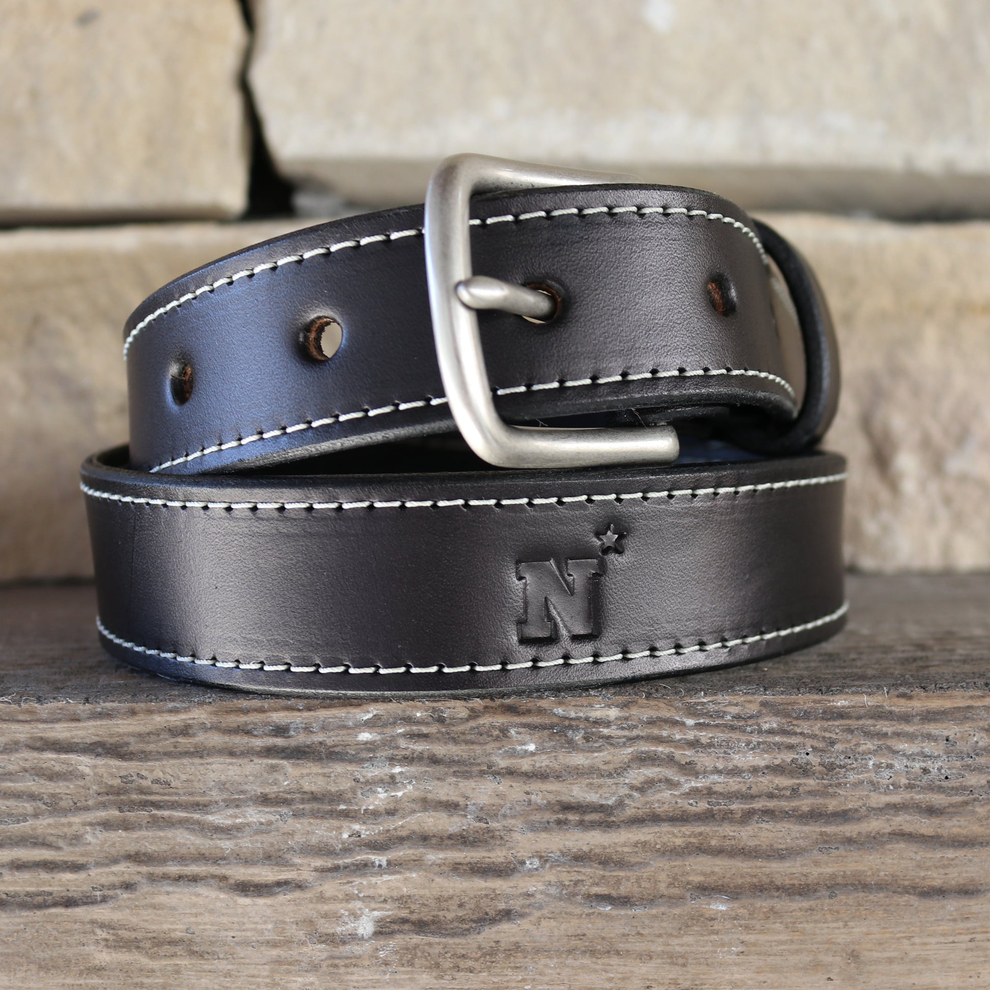 black leather belt debossed with naval academy N-star